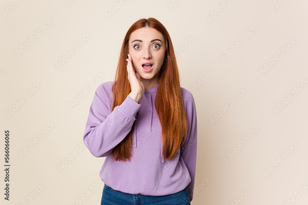 Young red hair woman isolated shouts loud, keeps eyes opened and hands tense. Young red hair woman isolated shouts loud, keeps eyes opened and hands tense.