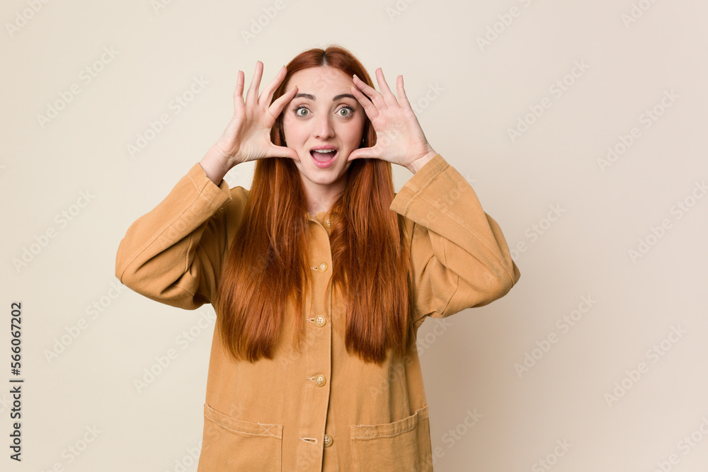 Young red hair woman isolated receiving a pleasant surprise, excited and raising hands. Young red hair woman isolated receiving a pleasant surprise, excited and raising hands.