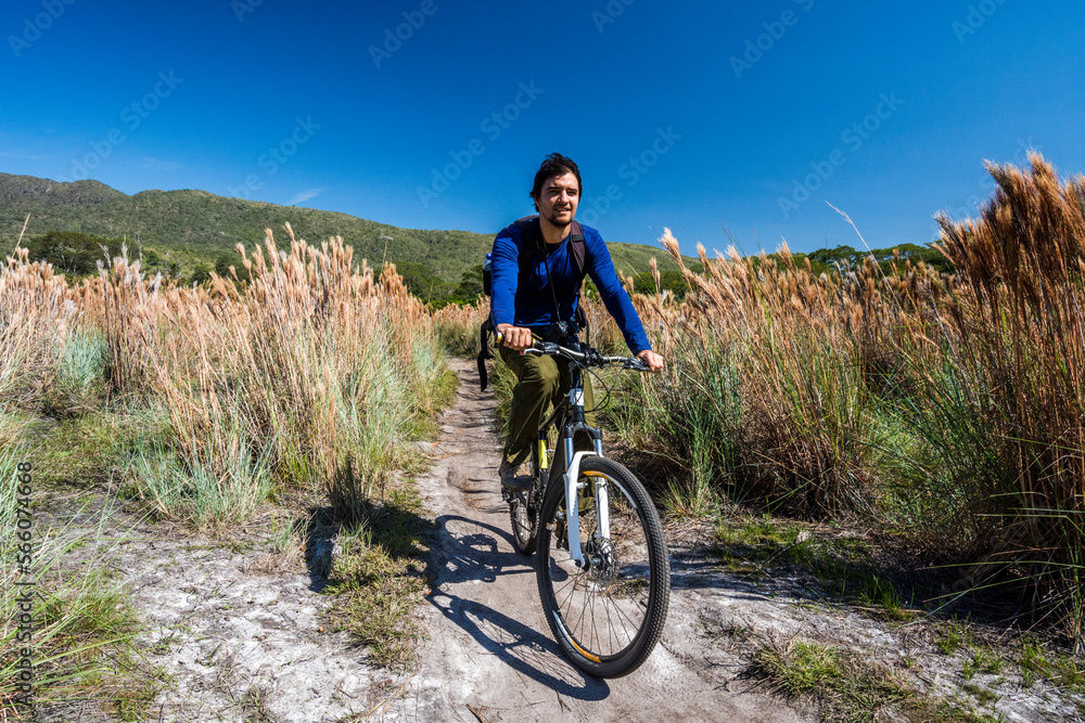 Man riding bicycle in natural scenery in Serra do Cipo National Park, Minas Gerais, Brazil Man riding bicycle in natural scenery in Serra do Cipo National Park, Minas Gerais, Brazil