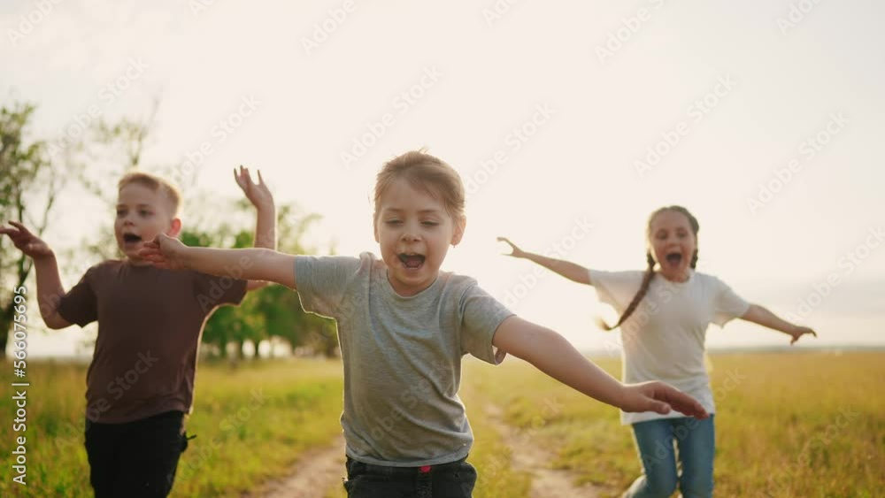 children in the park. a group of children in a team hands to the sides run screaming play pilot dream of becoming a pilot. happy family kid dream concept. a team children run through sun the park children in the park. a group of children in a team hands to the sides run screaming play pilot dream of becoming a pilot. happy family kid dream concept. a team children run through sun the park