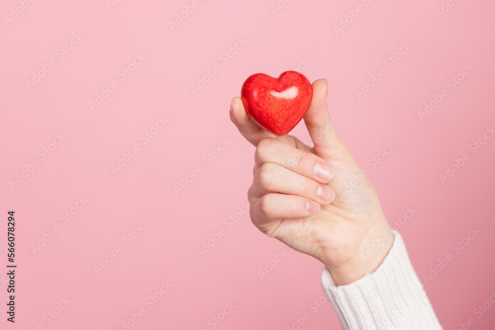 closeup hands holding heart on pink background, valentine's day concept closeup hands holding heart on pink background, valentine's day concept