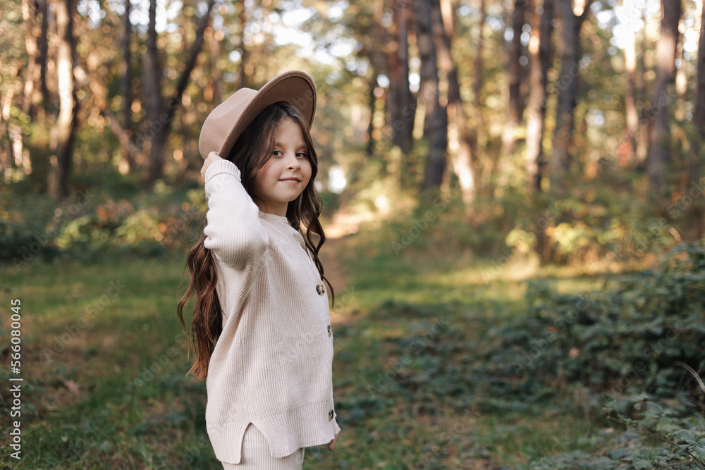 Portrait of beautiful little girl in hat looking at camera and smiling. Happy cute child having fun in park outdoors, enjoying childhood, be in good mood. Dream of child and happiness of child Portrait of beautiful little girl in hat looking at camera and smiling. Happy cute child having fun in park outdoors, enjoying childhood, be in good mood. Dream of child and happiness of child