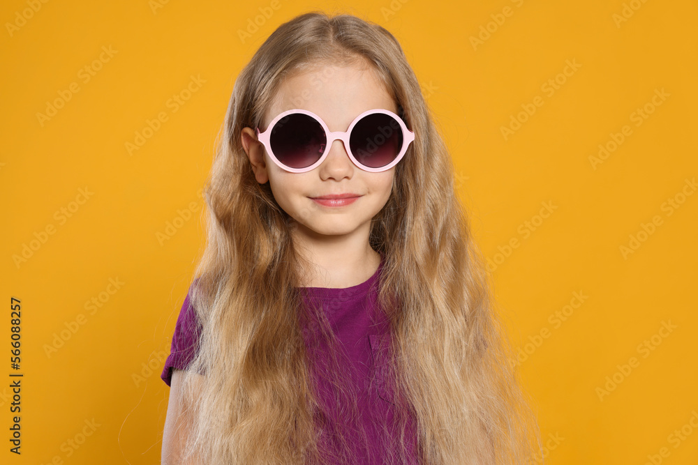 Girl in stylish sunglasses on orange background Girl in stylish sunglasses on orange background