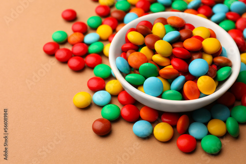 Tasty colorful candies on light brown background, closeup. Space for text