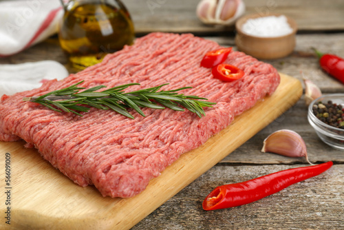 Raw fresh minced meat and ingredients on wooden table, closeup