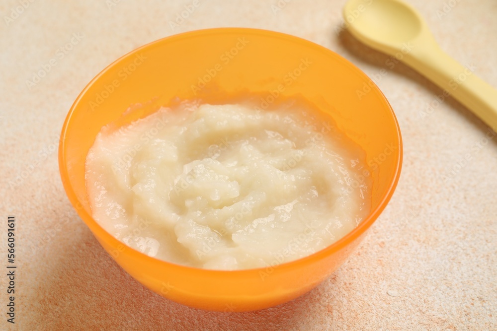 Baby food. Bowl with cauliflower puree served on beige textured table, closeup Baby food. Bowl with cauliflower puree served on beige textured table, closeup