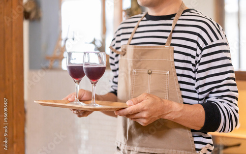 飲食店・バー・居酒屋・ワインバー・バル・ワインショップで赤ワインを持つ男性(ソムリエ・シェフ) photo