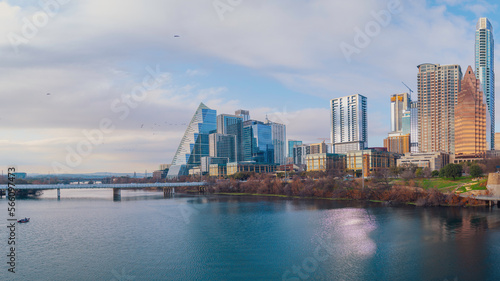 Warm vibrant Austin Texas city skyline and modern buildings over the tranquil Lady Bird Lake water sports recreational area and Colorado River with the view of First Street Jefferson Davis Bridge
