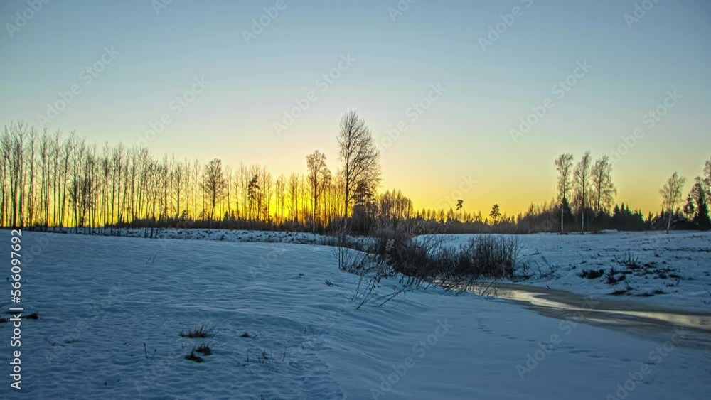 Bright yellow sun setting down behind winter landscape, fusion time lapse Bright yellow sun setting down behind winter landscape, fusion time lapse