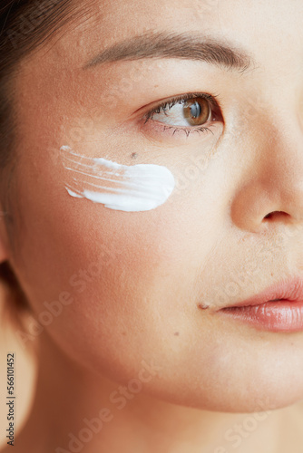 Closeup on woman with facial cream on face