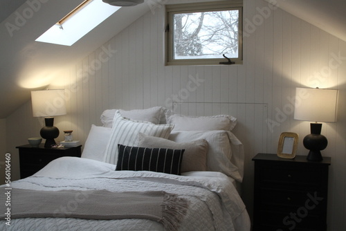Foto Modern designer bedroom with pillows, night tables, window and skylight over the