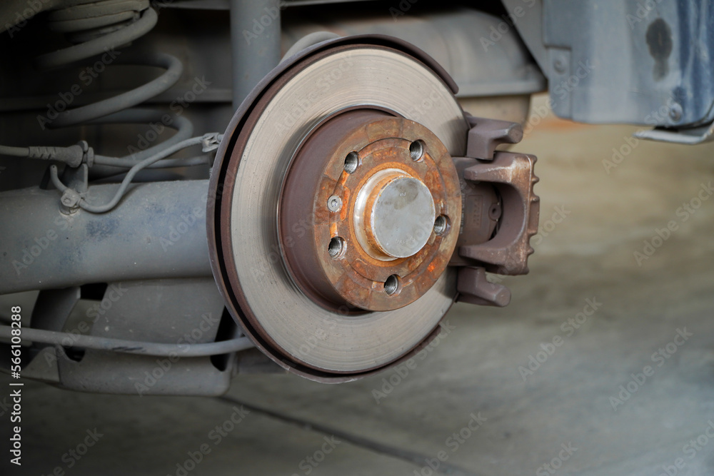 Car brake disc for garage repair
, in process of new tire replacement. Car brake repairing in garage.Suspension of car for maintenance brakes and shock absorber systems.Close up.