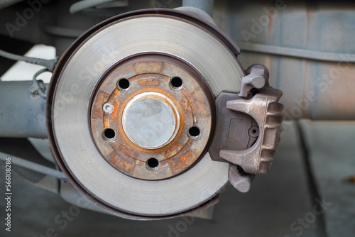 Car brake disc for garage repair , in process of new tire replacement. Car brake repairing in garage.Suspension of car for maintenance brakes and shock absorber systems.Close up.