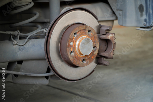 Car brake disc for garage repair , in process of new tire replacement. Car brake repairing in garage.Suspension of car for maintenance brakes and shock absorber systems.Close up.