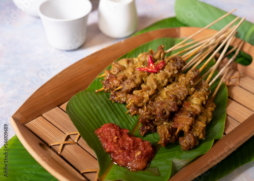 Sate usus or chickens intestines satay. traditional Indonesian street food. On banana leaf and traditional bamboo plate. Selective Focus photo