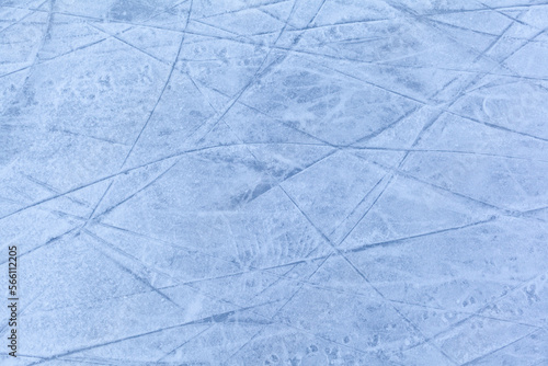 Empty ice rink with skate marks after the session outdoor. skating ice rink texture covered with snow in daylight. Close up of blue ice rink floor  copy space