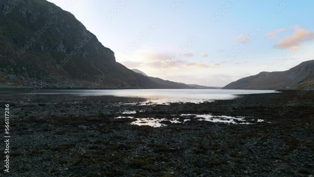 Ripples from the wind dance across the surface of a sea loch (Gleann Dubh) at low tide in the highlands of Scotland at sunset, surrounded by mountains. Ripples from the wind dance across the surface of a sea loch (Gleann Dubh) at low tide in the highlands of Scotland at sunset, surrounded by mountains.