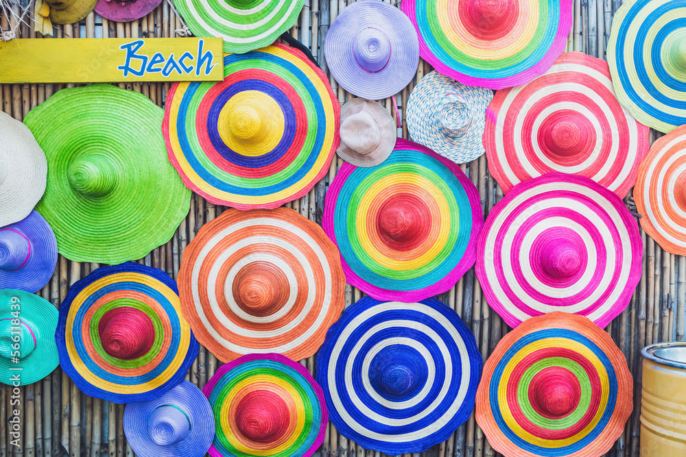 A variety of fashionable and colorful hats hanging on the bamboo