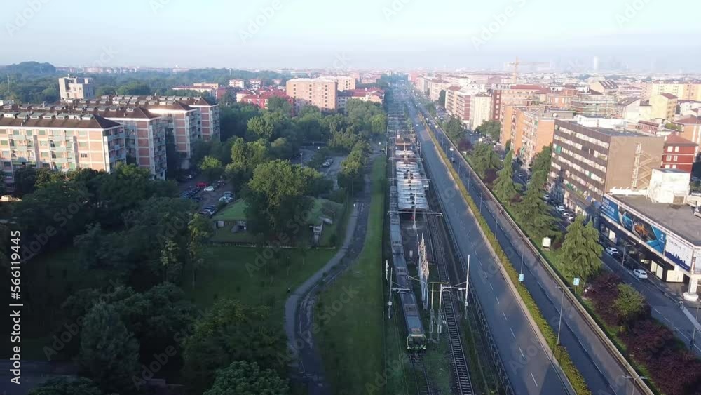 Subway leaving station in suburbs of Milan city, aerial drone view