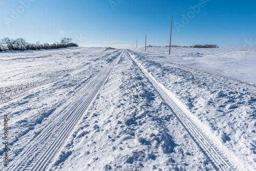 Vehicle tracks through deep snow on a rural road in Saskatchewan, Canada © Nancy Anderson
