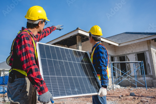 A team of two professional male engineers installing solar panels. working on a construction site Two technicians installing solar panels on the roof of a house