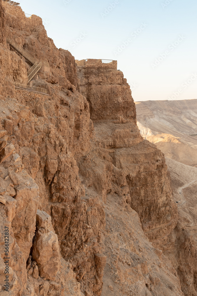 The remains  of outer walls in the rays of the rising sun in the ruins of the fortress of Masada - is a fortress built by Herod the Great on a cliff-top off the coast of the Dead Sea, Israel