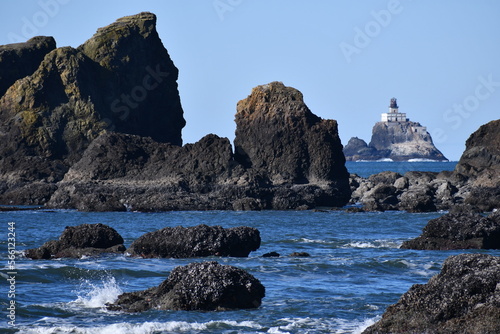 Dangerous rocky formations with lighthouse in the background. photo