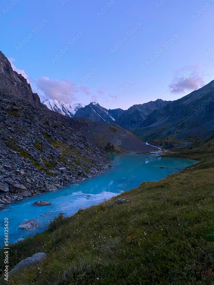 Mountain lake calm turquoise with clear water Karakabak in the Altai mountains with snow and glaciers in the evening at sunset. Vertical frame.