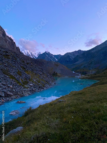 Fototapeta Naklejka Na Ścianę i Meble -  Mountain lake calm turquoise with clear water Karakabak in the Altai mountains with snow and glaciers in the evening at sunset. Vertical frame.