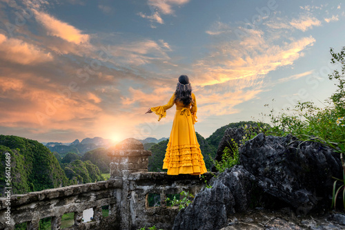 Asian woman on Hang Mua viewpoint at Tam Coc, Ninh Binh. Vietnam and sunset sky