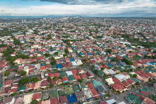 Aerial of the suburbs of Las Pinas with the Alabang skyline in the distant background.