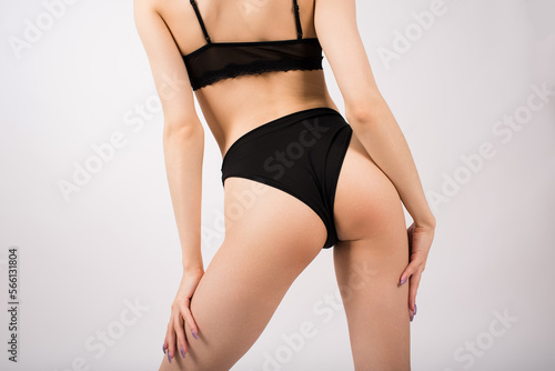 Close-up of female buttocks in lingerie on a white background.