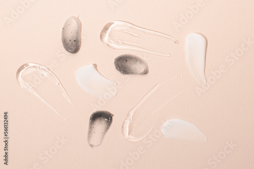 Cosmetic texture closeup on a beige background top view. Body cream, scrub, serum smears of body care products.