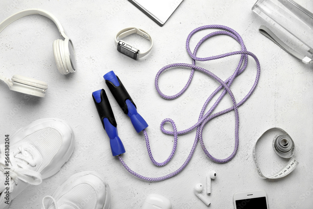 Skipping rope, gadgets, measuring tape and sneakers on white background Skipping rope, gadgets, measuring tape and sneakers on white background