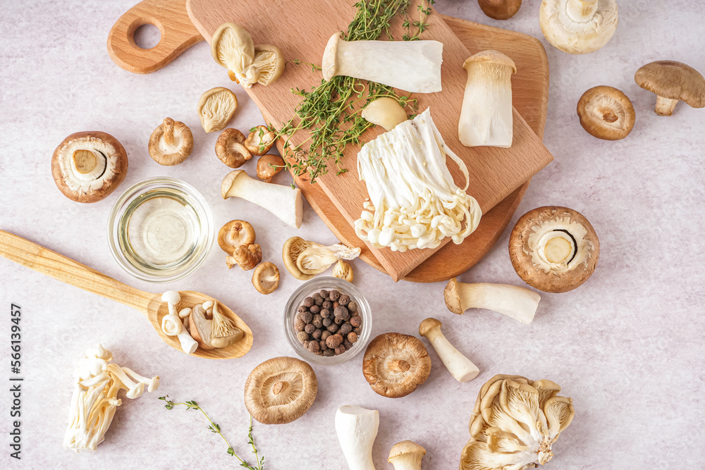 Composition with fresh mushrooms, thyme, oil and allspice on light background