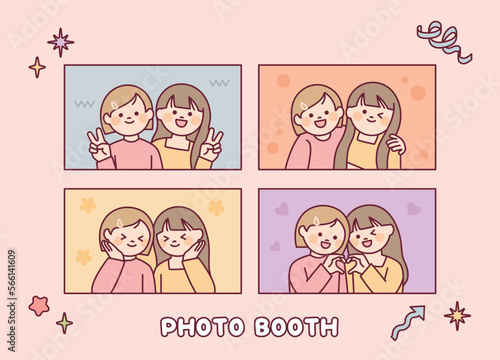 Two girls are taking pictures in various poses. Photo booth.