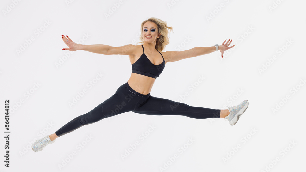 Athletic young woman jumps on a white background. Isolated background. Sportswoman
