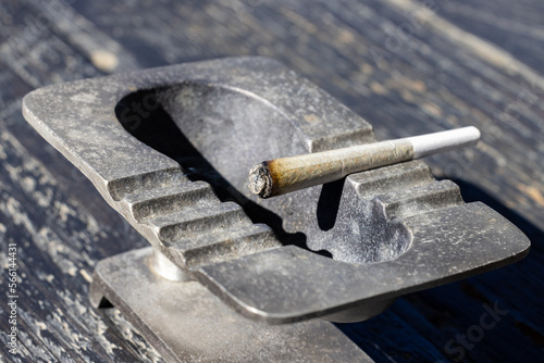 Close up on a lit joint sitting in an ashtray  photo