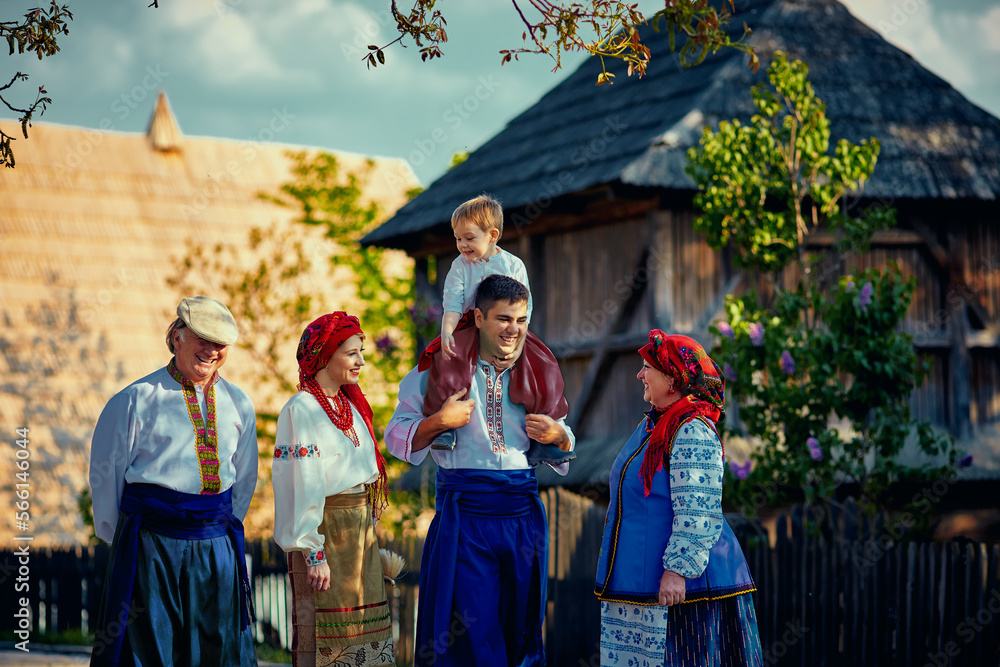 happy ukrainian family in traditional costumes walking down an old village street