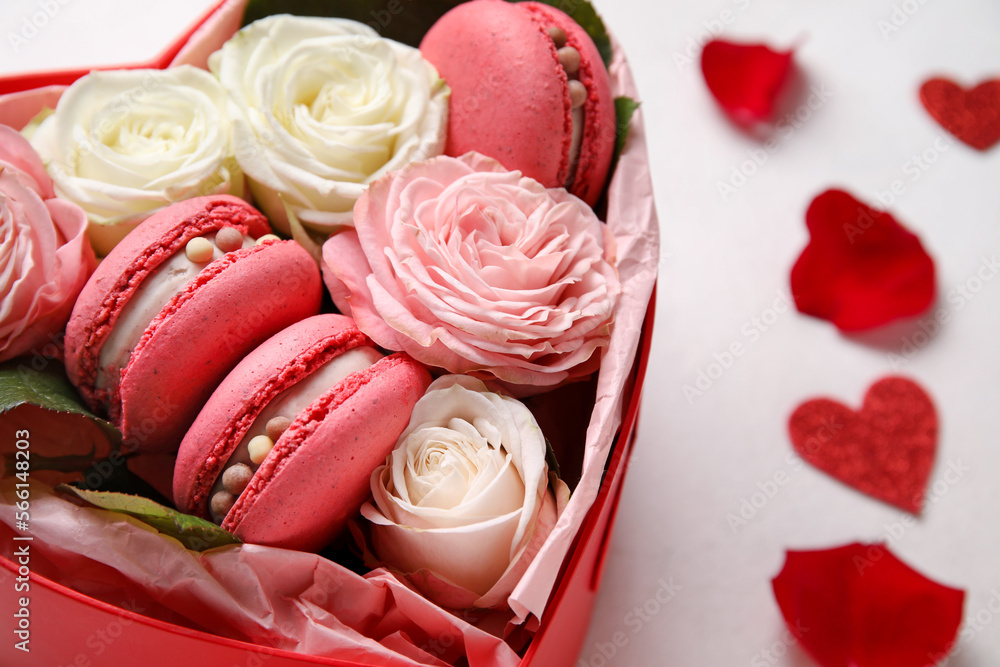 Box with tasty macaroons, rose flowers and hearts on white background. Valentine's Day celebration Box with tasty macaroons, rose flowers and hearts on white background. Valentine's Day celebration