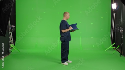 Wallpaper Mural Male doctor standing on a Green Screen, Man making notes. Chroma Key Torontodigital.ca