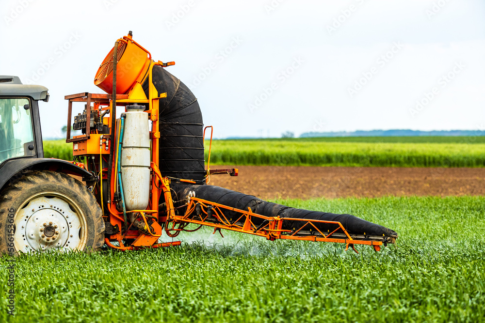 Tractorapplied herbicides, pesticides, and fungicides in wheat fields, farmer protecting crops