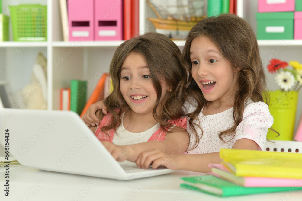 Two cute little girls at class with laptop Two cute little girls at class with laptop