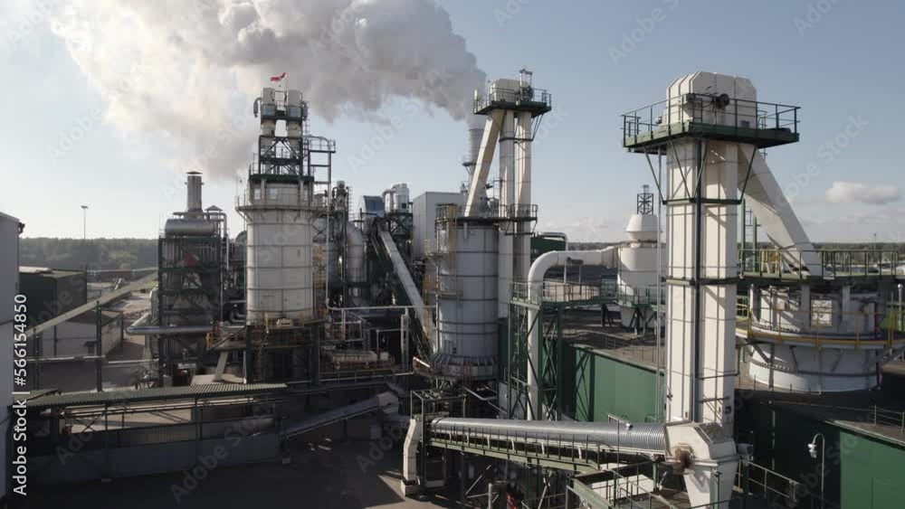 Large wood processing factory, view of the steel pipes and tanks from height, industrial structure of the plant, smoke coming from the pipes. Large wood processing factory, view of the steel pipes and tanks from height, industrial structure of the plant, smoke coming from the pipes.