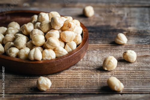 Heap of roasted hazelnuts close-up on a wooden background.