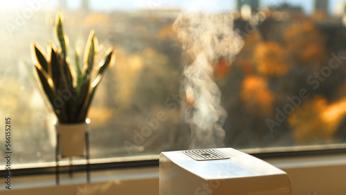 Foto Air humidifier making hot steam to increase humidity at home in dry winter weather