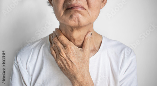 Tightness at the neck of Asian elder man. Concept of sore throat, pharyngitis, laryngitis, esophagitis, thyroiditis, thyrotoxicosis, dysphagia, choking or gasping. photo