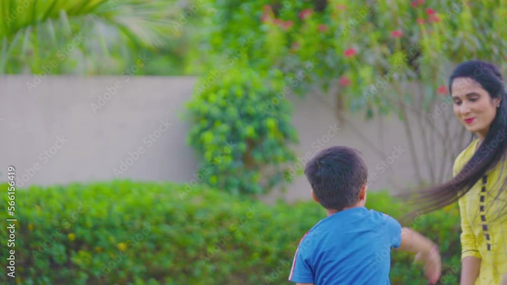 Indian Mom with her cute son, child playing together, running, chasing, laughing, fighting, having fun, joy making face expressions in beautiful green garden. Mother's Day concept. Slow motion Indian Mom with her cute son, child playing together, running, chasing, laughing, fighting, having fun, joy making face expressions in beautiful green garden. Mother's Day concept. Slow motion