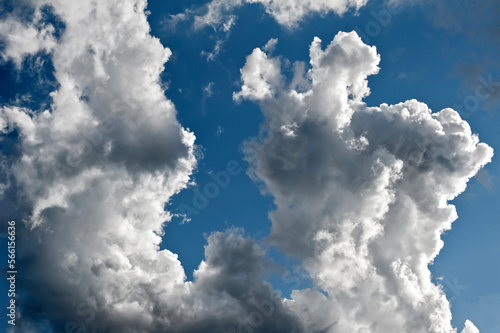 Aufsteigende, zerzauste Haufenwolken am blauem Himmel bei schönem Sommerwetter photo