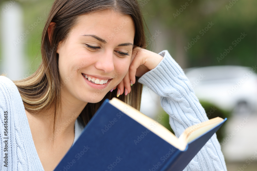 Happy teen reading a book outside Happy teen reading a book outside